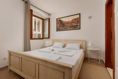 a bedroom with a large bed with white sheets at Apartment Amigo 2 Old Town Kotor in Kotor
