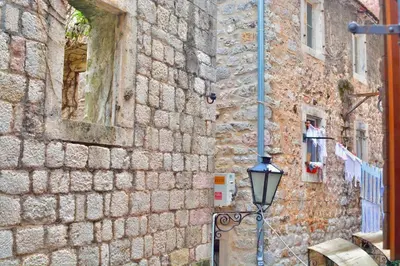 a street light next to a brick wall with a building at Apartment Amigo 2 Old Town Kotor in Kotor