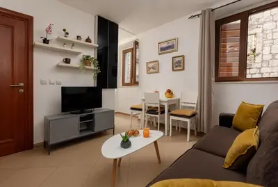 a living room with a couch and a tv and a table at Apartment Amigo 2 Old Town Kotor in Kotor