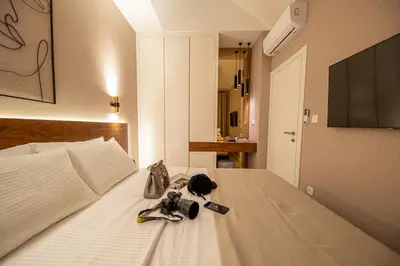 a hotel room with a bed with shoes and a television at Enyana Luxury Suites in Kotor