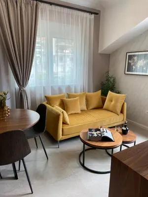 a living room with a yellow couch and a table at Enyana Luxury Suites in Kotor