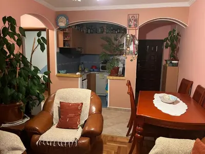 a living room with a table and a chair and a kitchen at PA Max apartment in Kotor
