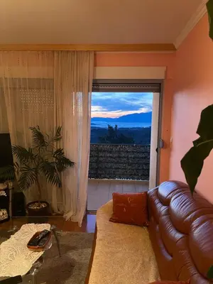 a living room with a couch and a large window at PA Max apartment in Kotor