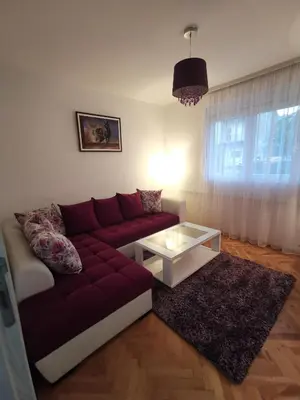 a living room with a red couch and a coffee table at Art Apartment in Podgorica