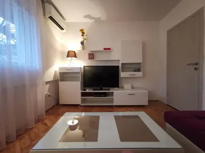 a living room with a tv and a table at Art Apartment in Podgorica