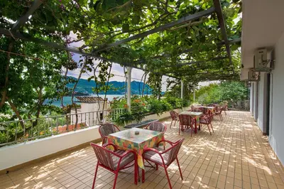 a group of tables and chairs on a patio at Madra Rooms and Apartments in Budva