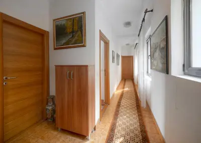 a hallway with a wooden door and a hallway with a window at Madra Rooms and Apartments in Budva