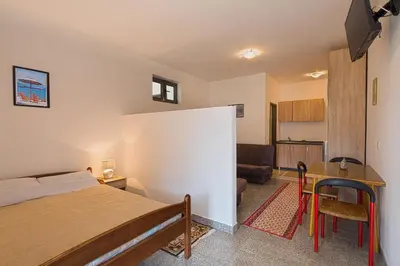 a bedroom with a bed and a table and a couch at Madra Rooms and Apartments in Budva