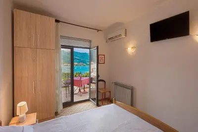 a bedroom with a bed and a window with a view at Madra Rooms and Apartments in Budva