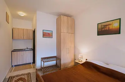 a bedroom with a bed and a wooden cabinet at Madra Rooms and Apartments in Budva