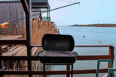 a black chair sitting next to a body of water at River house Velero in Ulcinj