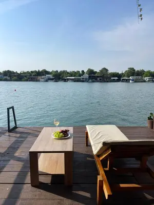 a table and a glass of wine on a dock at River house Velero in Ulcinj