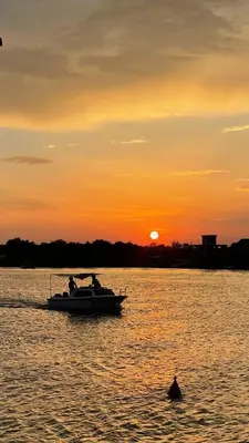 a boat in the water with the sunset in the background at River house Velero in Ulcinj