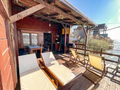 a porch with two chairs and a table and a bed at River house Velero in Ulcinj