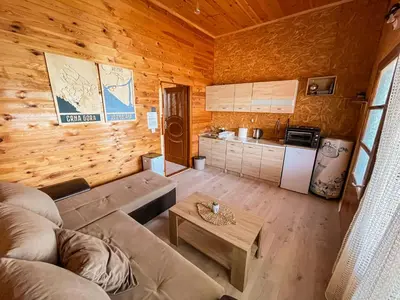 a living room with a couch and a table and a kitchen at River house Velero in Ulcinj
