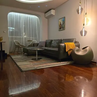 a living room with a leather couch and a table at Rosewood Podgorica in Podgorica