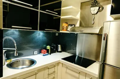 a small kitchen with a sink and a refrigerator at Rosewood Podgorica in Podgorica