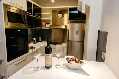 a kitchen with a bottle of wine and two glasses at Rosewood Podgorica in Podgorica