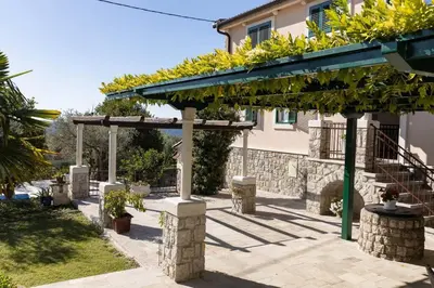 a pergola in front of a building with plants on it at Villa Ella in Stari Bar