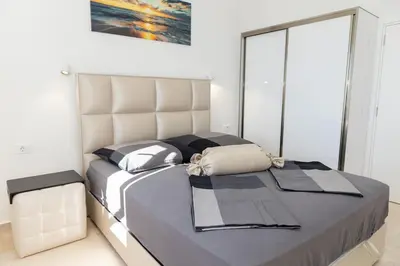 a bedroom with a large bed with a large headboard at Villa Ella in Stari Bar