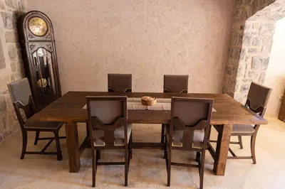a dining room table with chairs and a clock at Villa Ella in Stari Bar