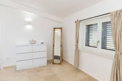 a room with a mirror and a dresser and a window at Villa Ella in Stari Bar