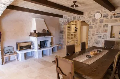 a dining room with a table and a fireplace at Villa Ella in Stari Bar