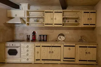 a kitchen with wooden cabinets and a white stove top oven at Villa Ella in Stari Bar