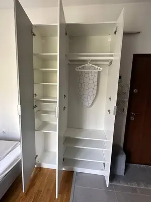 a white walk in closet with white shelves at Cozy studio Bečići in Becici
