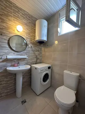 a bathroom with a washing machine and a sink at Cozy studio Bečići in Becici