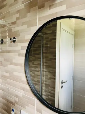 a round mirror on a wall with a door at Cozy studio Bečići in Becici