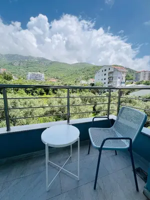 two chairs and a table on a balcony with a view at Cozy studio Bečići in Becici