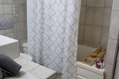 a bathroom with a shower with a white shower curtain at Luxury place with a magnificent view in Budva