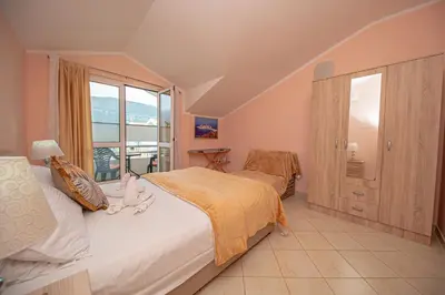 a bedroom with a bed and a large window at Fairytale 1 and 2 in Budva