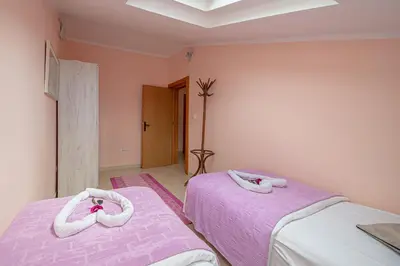 two beds in a room with pink sheets at Fairytale 1 and 2 in Budva