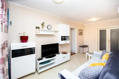a living room with a couch and a flat screen tv at Fairytale 1 and 2 in Budva
