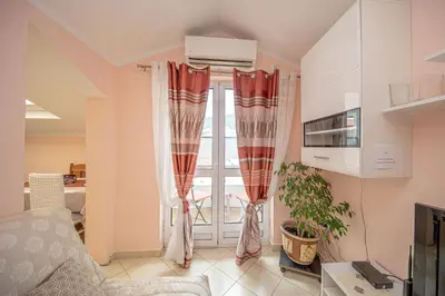 a living room with red curtains and a window at Fairytale 1 and 2 in Budva