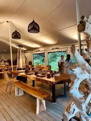 a room with a large wooden table with people in the background at Ashuma Retreat in Cetinje