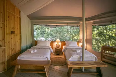 two beds in a room with two windows at Ashuma Retreat in Cetinje