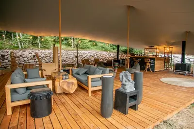 a tent with couches and chairs on a wooden deck at Ashuma Retreat in Cetinje