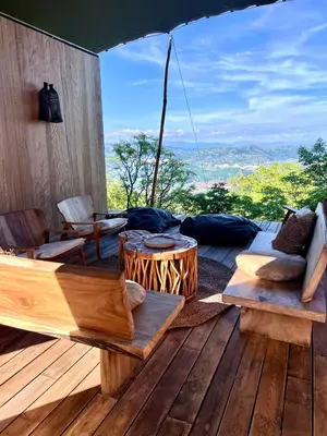 a patio with benches and a table on a wooden deck at Ashuma Retreat in Cetinje