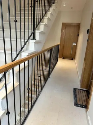 a staircase with black railings and a wooden door at Saly Apart in Budva