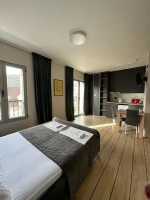 a bedroom with a large bed and a dining room at Saly Apart in Budva