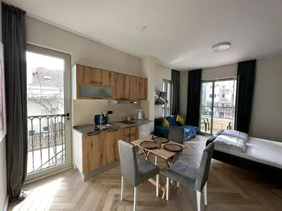 a kitchen and living room with a table and chairs at Saly Apart in Budva