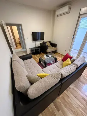 a large couch in a living room with a television at Selena apartment in Podgorica