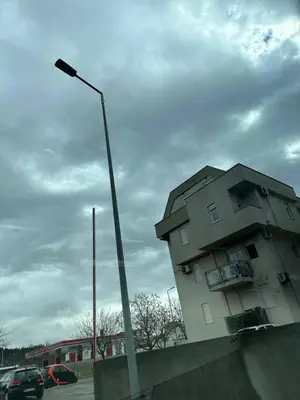a building in a parking lot with a street light at Selena apartment in Podgorica