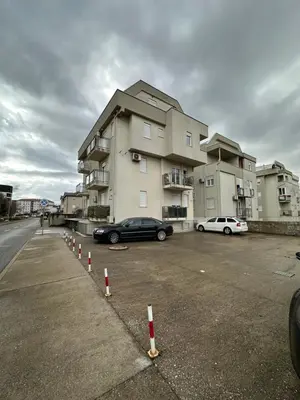 a parking lot with cars parked in front of a building at Selena apartment in Podgorica