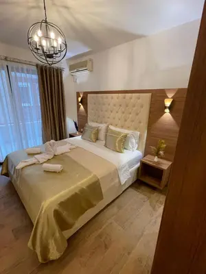 a bedroom with a large bed and a chandelier at Apartments Miri in Ulcinj