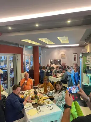 a group of people sitting at tables in a restaurant at Apartments Miri in Ulcinj