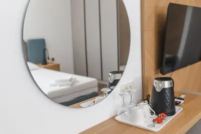 a bathroom with a mirror and a room with a bed at Apartments Mara Lux in Budva